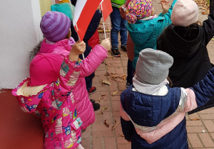 Dzieci machają własnoręcznie wykonanymi flagami
